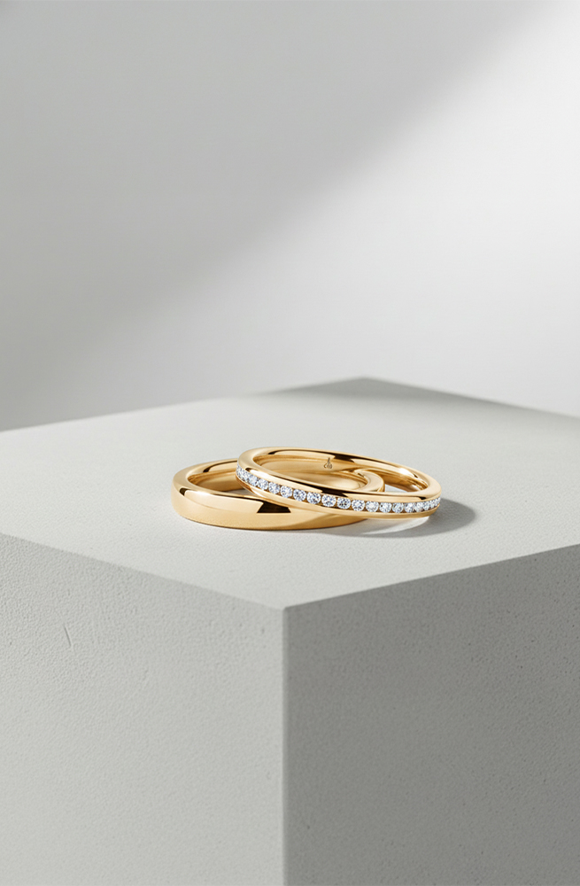 Goldene Trauringe mit Diamanten von Juwelier Otto Parr in Gießen, stilvoll auf Podest präsentiert.